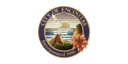 The City of Encinitas flag features a circular emblem with a coastal scene including a horse, a bird, a sunset, and a poinsettia. The text "CITY OF ENCINITAS Incorporated 1986" is visible around the emblem.