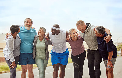 A diverse group of six older adults in athletic wear are standing together with their arms around each other, smiling and laughing.