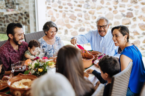 A multi-generational family enjoys a meal together outdoors.
